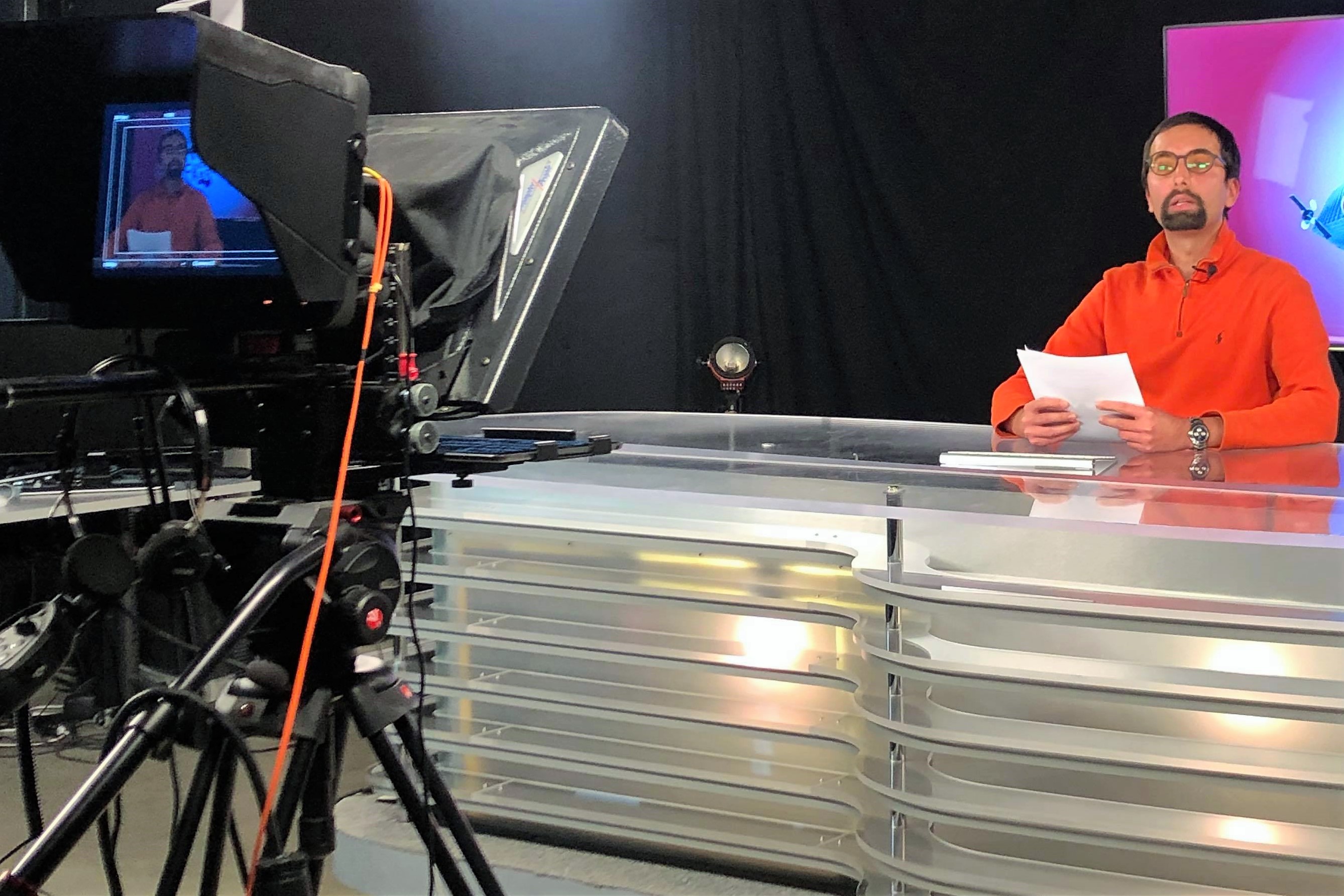 Photograph shows Abbas Mehrabian anchoring a TV newscast at Concordia TV studio in December 2020.