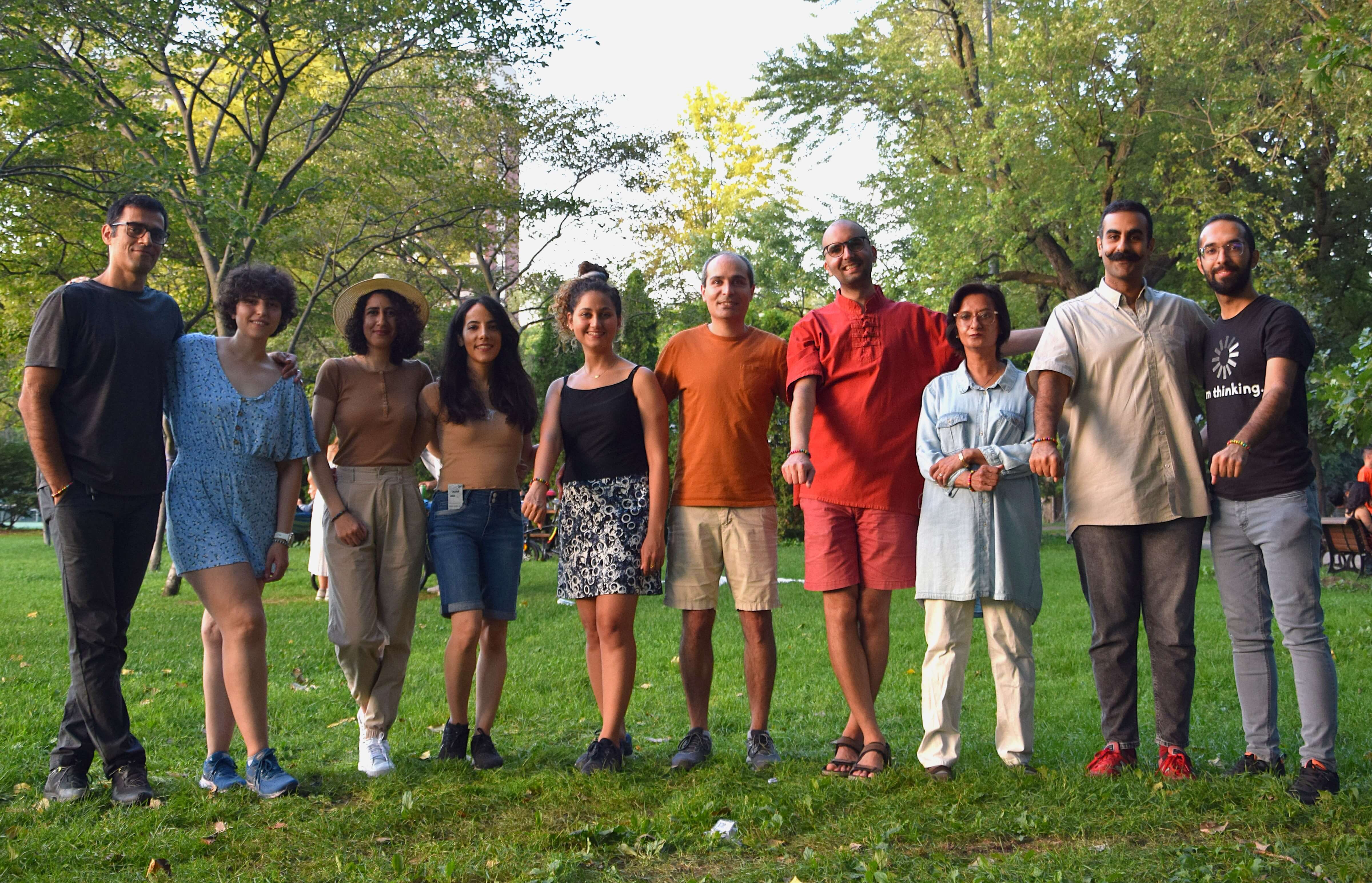 Photograph shows a group of people grouped in a park.